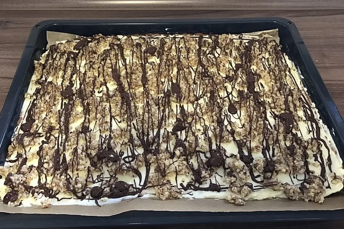 Saftiger Schokoladenkuchen mit Nussstreuseln und glänzender Schokoladenglasur auf einem rustikalen Holzbrett