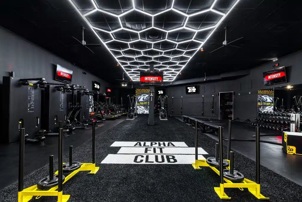 Premium boutique fitness studio with matte black training rig and warm lighting