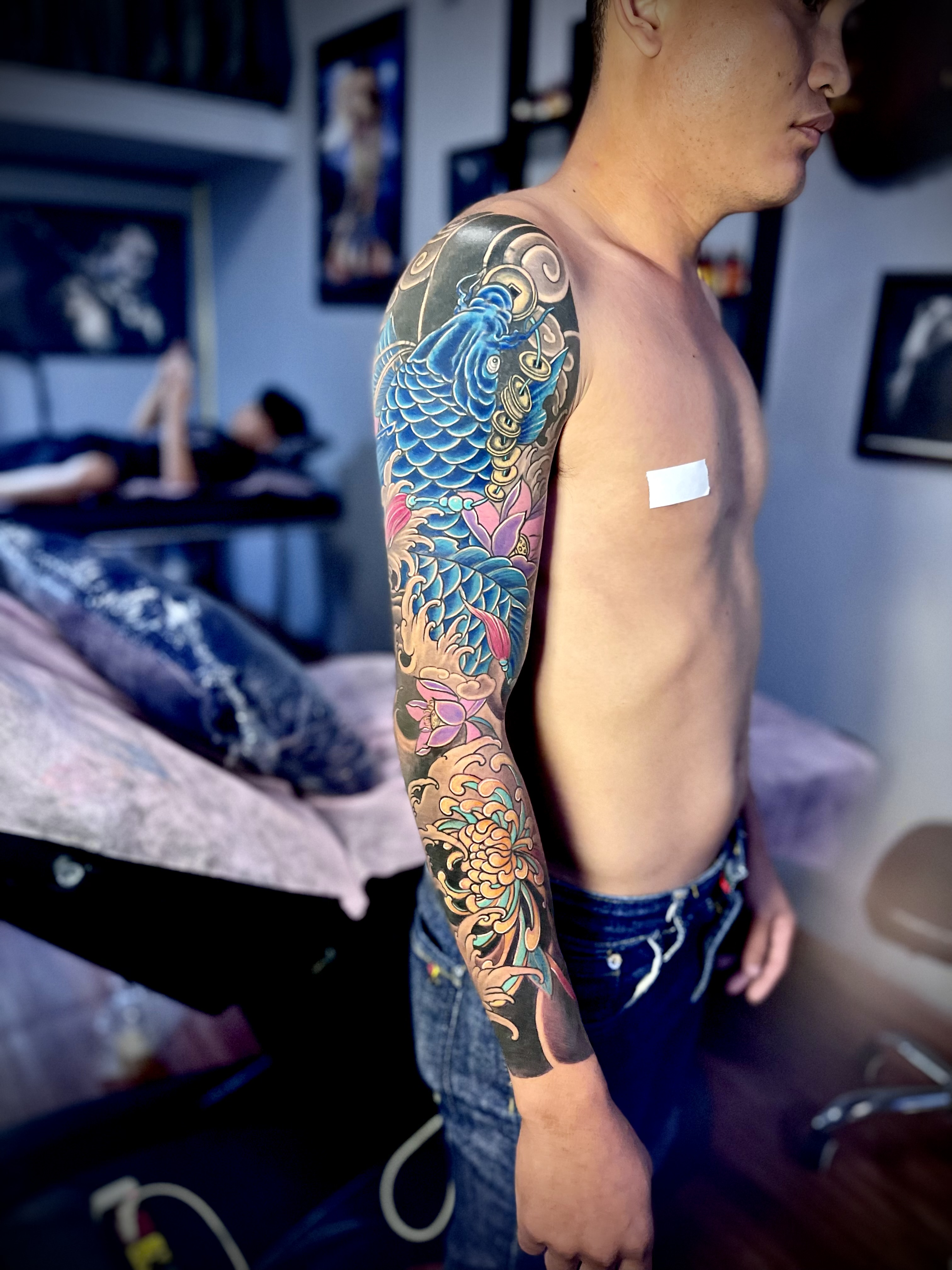Full sleeve carp tattoo done directly by Tran Ky Tattoo