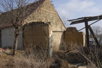 Kozojídky, v pozadí štít stodoly u čp. 6 z nepálených cihel a nabíjení, v popředí zřícenina stodoly u čp. 5