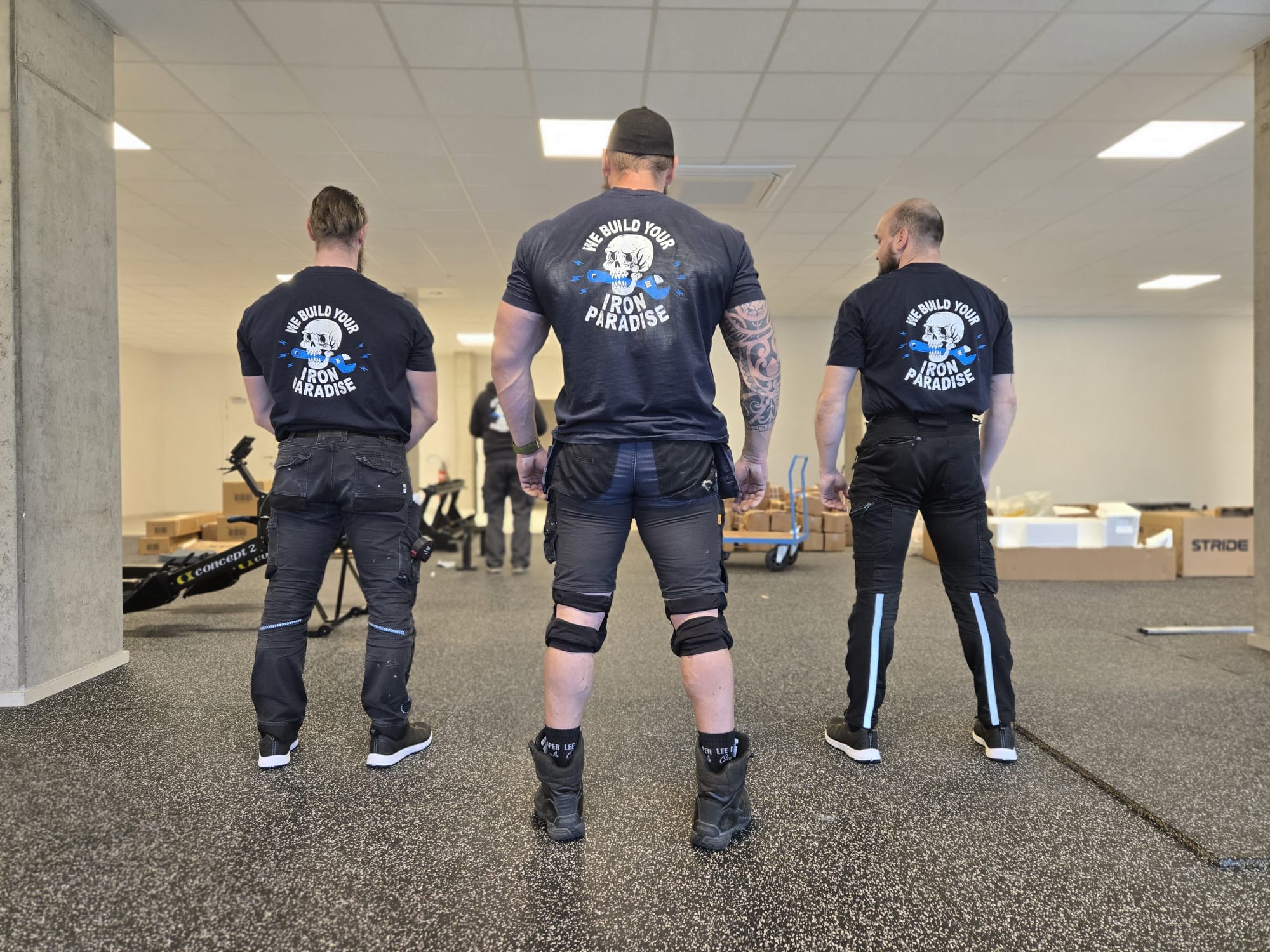 Team van Fitness Installations van achteren, met We build your iron paradise op de shirts