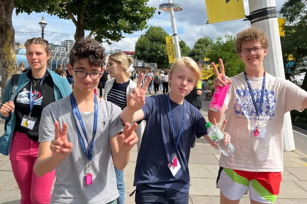 Oxford-London Program student group on a walking tour near the London Eye, waving to the camera and celebrating shared dreams and goals during their summer experience.
