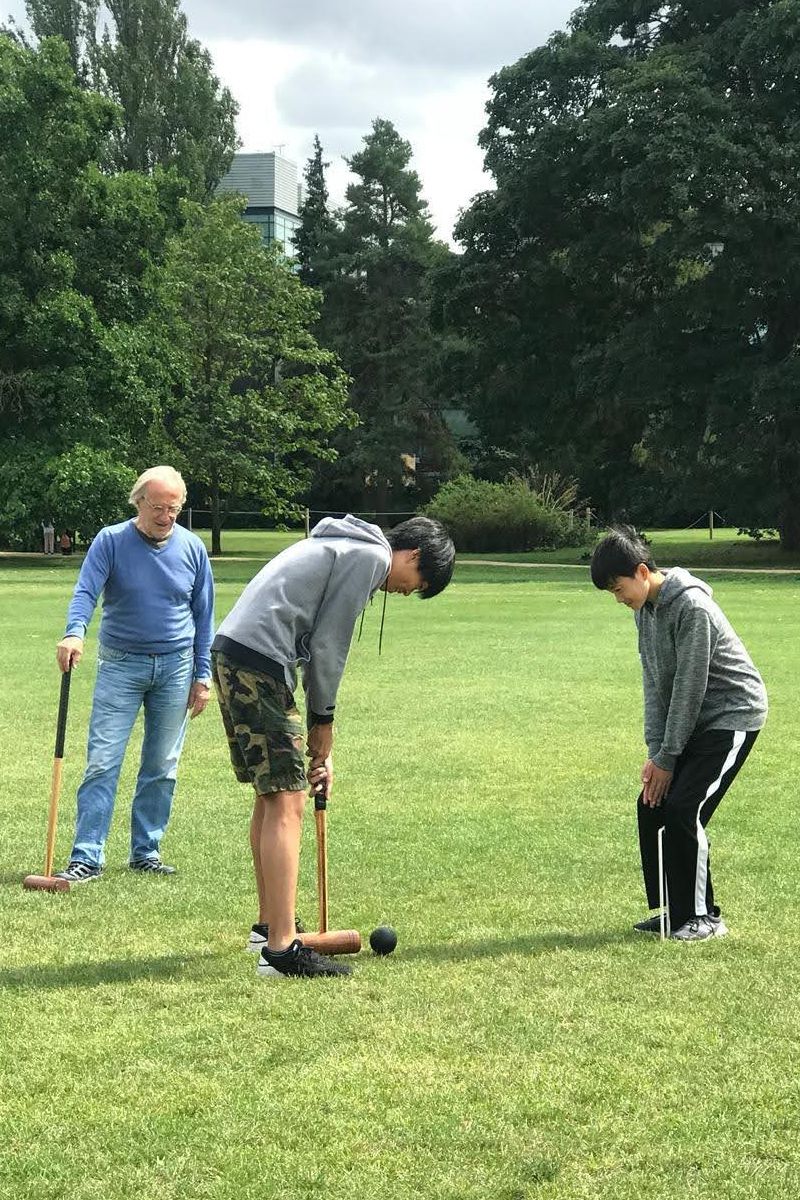 Oxford Summer Program group outdoor activity: Two Japanese students play croquet—a classic Oxford grass game—guided by the campus head instructor in University Parks