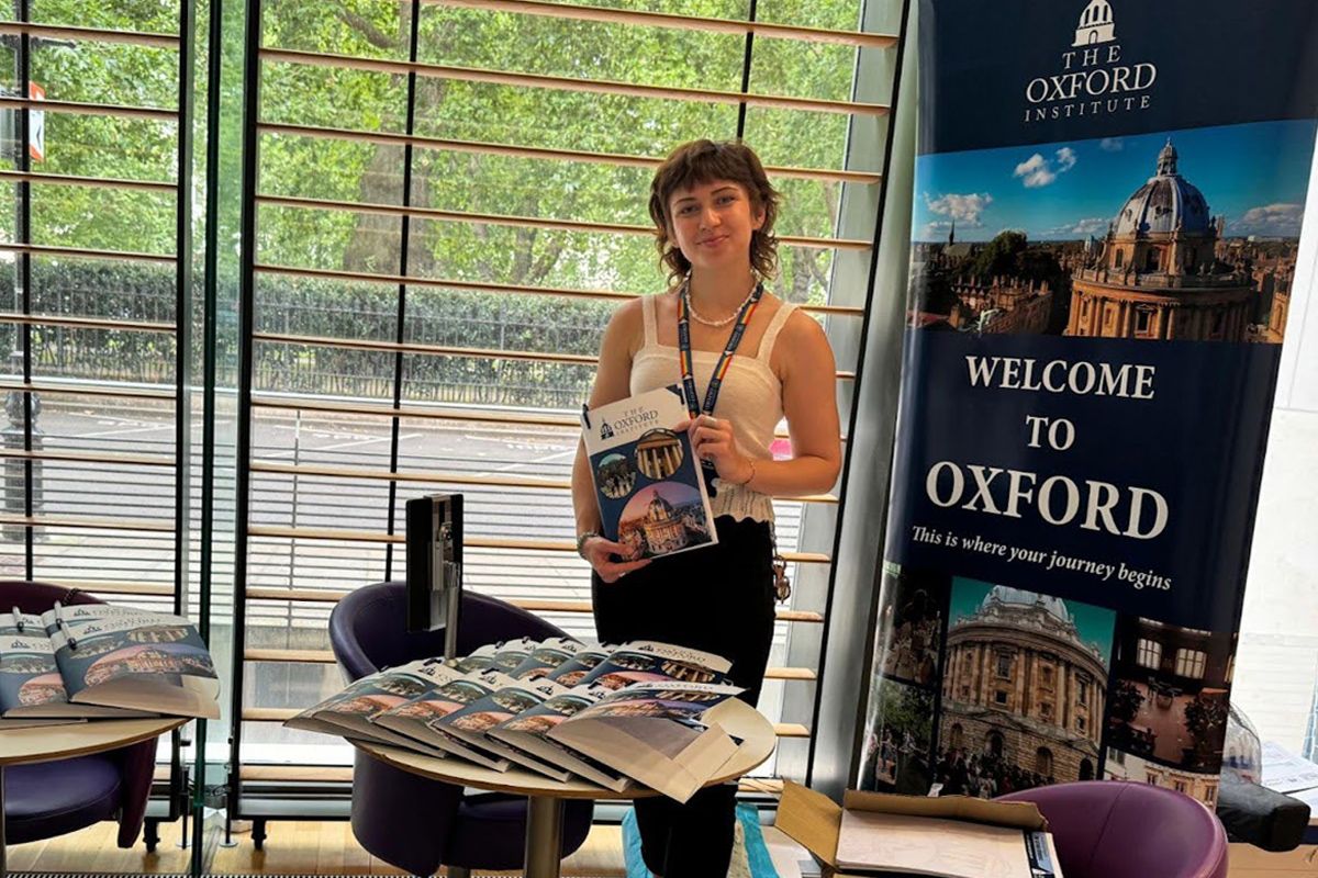 Residential Dean at the Oxford–London Summer Program stands at the help desk in Imperial Campus, ready to welcome incoming students traveling from abroad and arriving locally from across the UK.