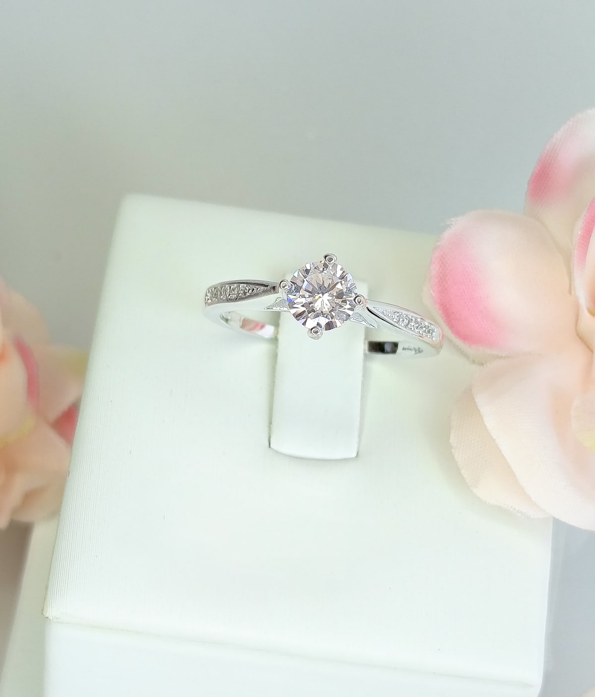 Anillo de plata con circón sobre un soporte blanco