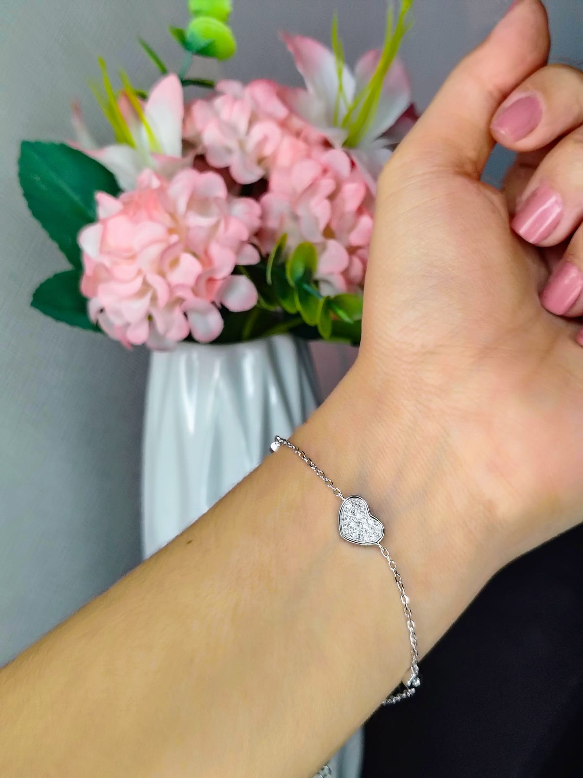 Pulsera de plata con corazón en la muñeca