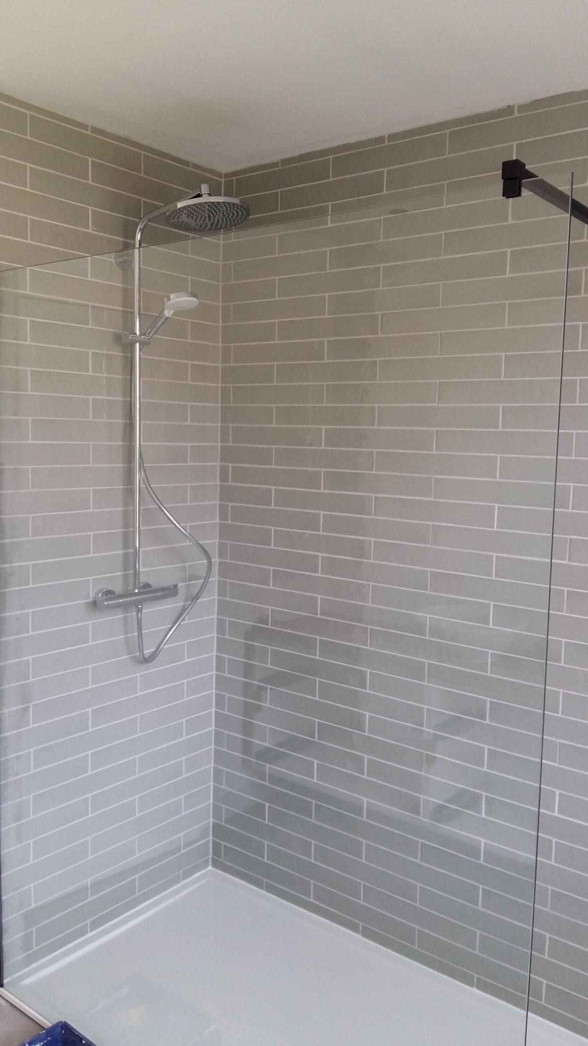 Betegelde douchewand met verticale groen-grijze wandtegels