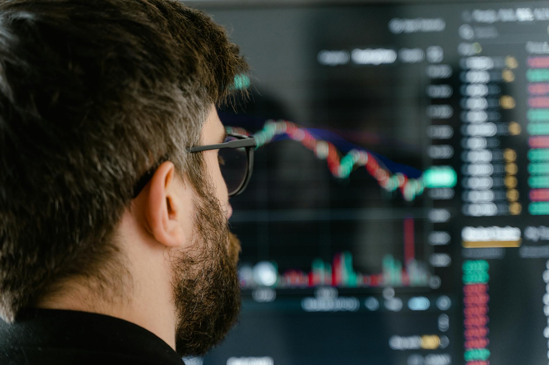 Trader observando una pantalla con gráficos