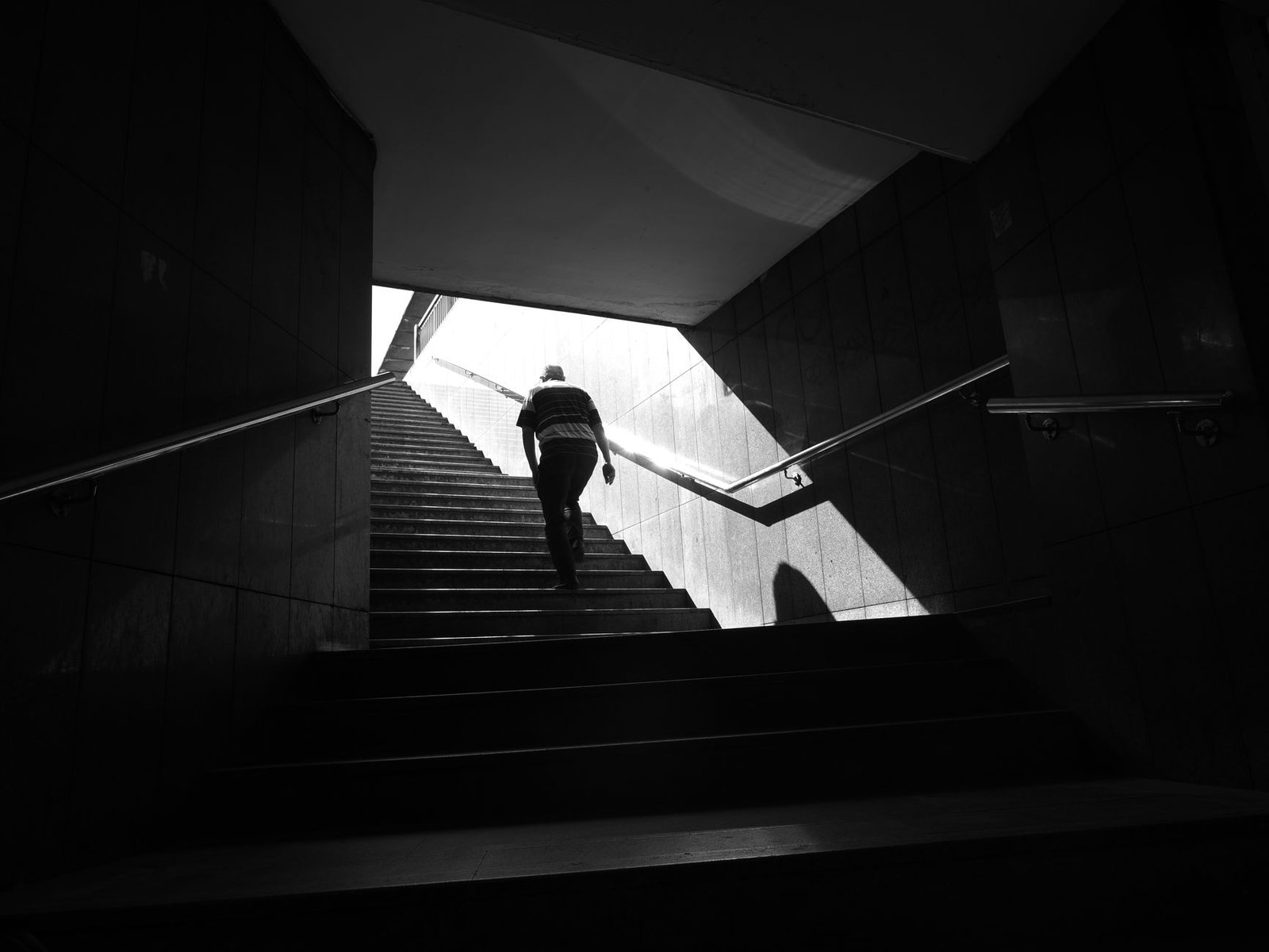 Una persona subiendo una escalera hacia la luz