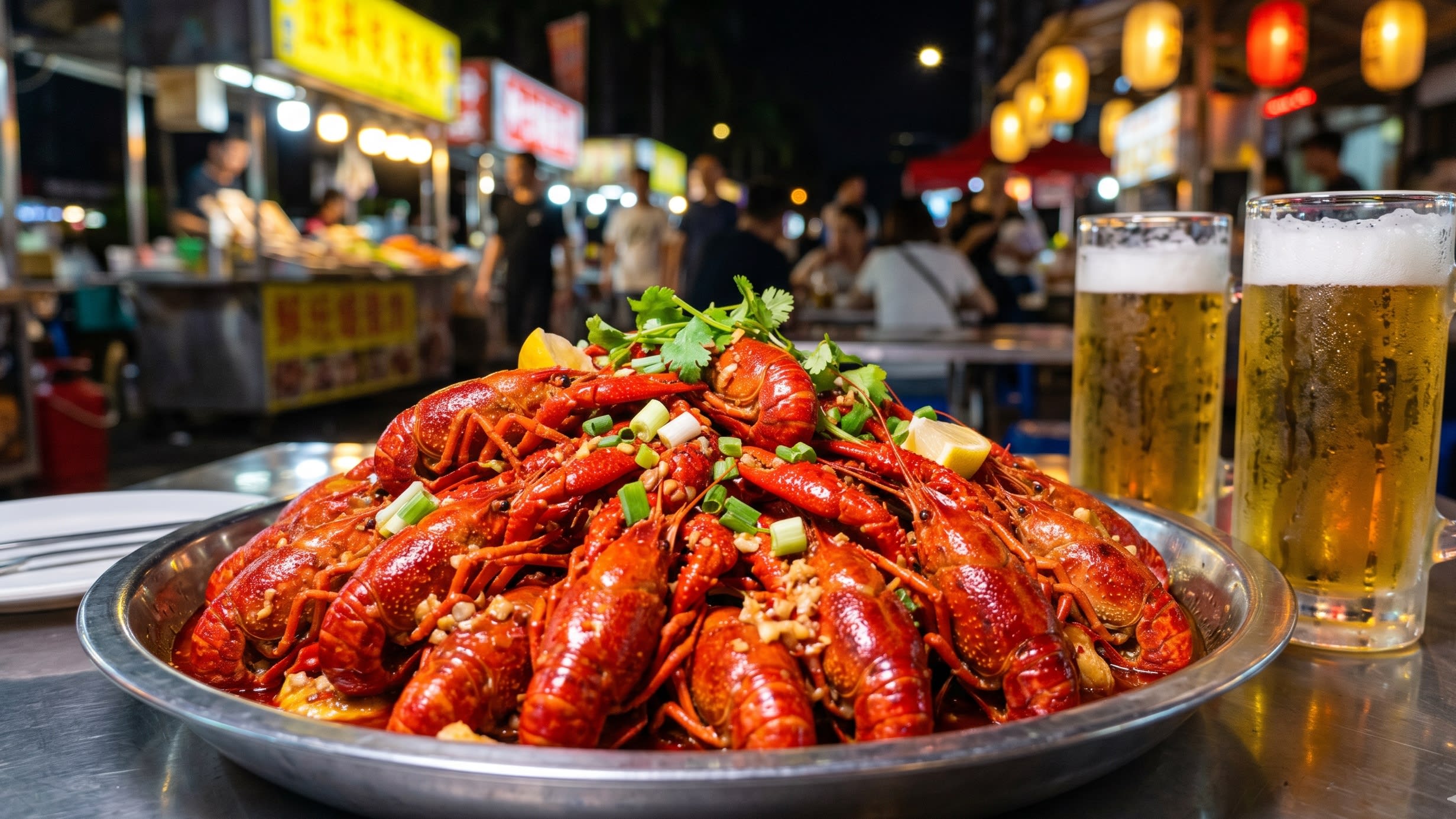 A close-up, mouth-watering food photography shot of a massive platter of bright red, spicy crawfish surrounded by cold glasses of draft beer on a busy outdoor dining table at night (16:9 ratio)