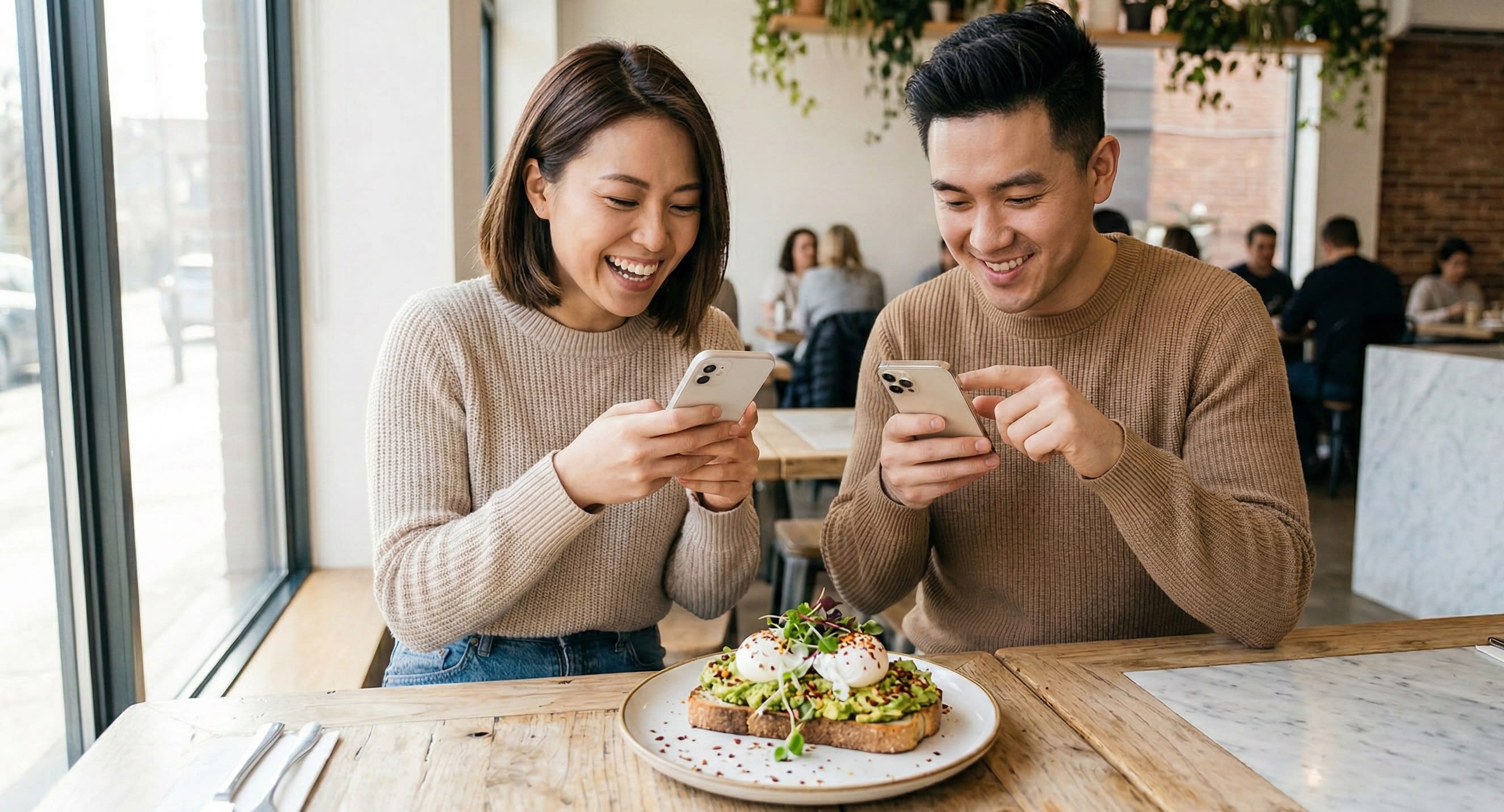 Two friends sitting at a cafe table taking pictures of their food, representing a 'fan dazi' or meal partner