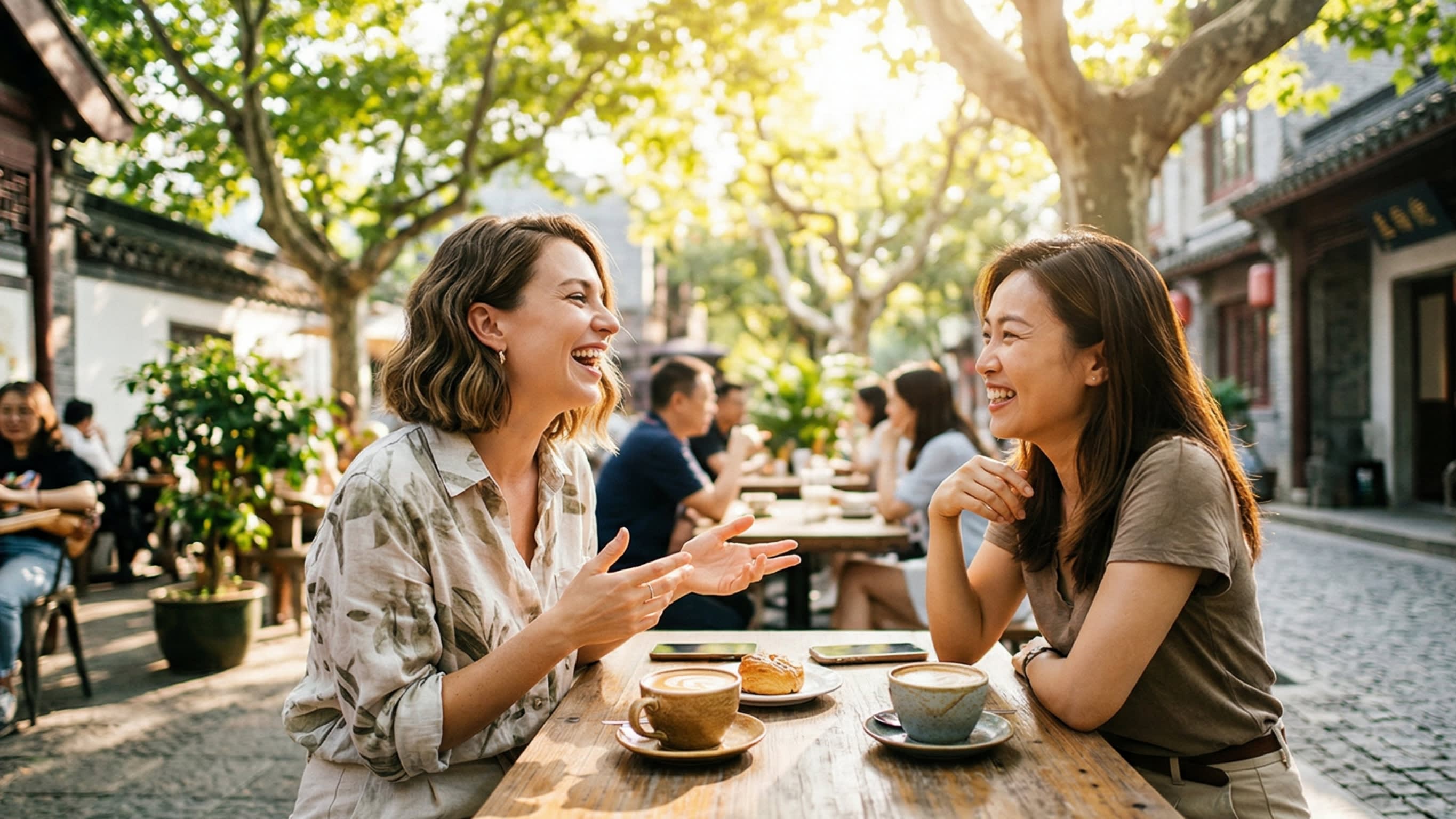 A bright, uplifting lifestyle photography shot of a confident, stylish international expat sitting at a sunny outdoor cafe in China, laughing joyfully while having a fluent, engaging conversation with a local Chinese friend. The image perfectly captures the ultimate goal of language learning: genuine human connection.