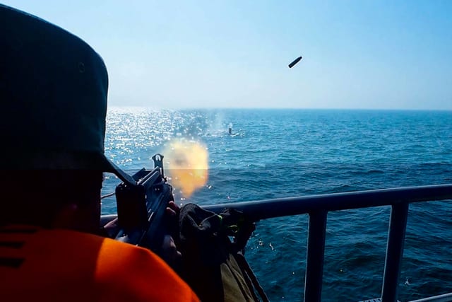 Damage control team conducting firefighting drill on ship deck