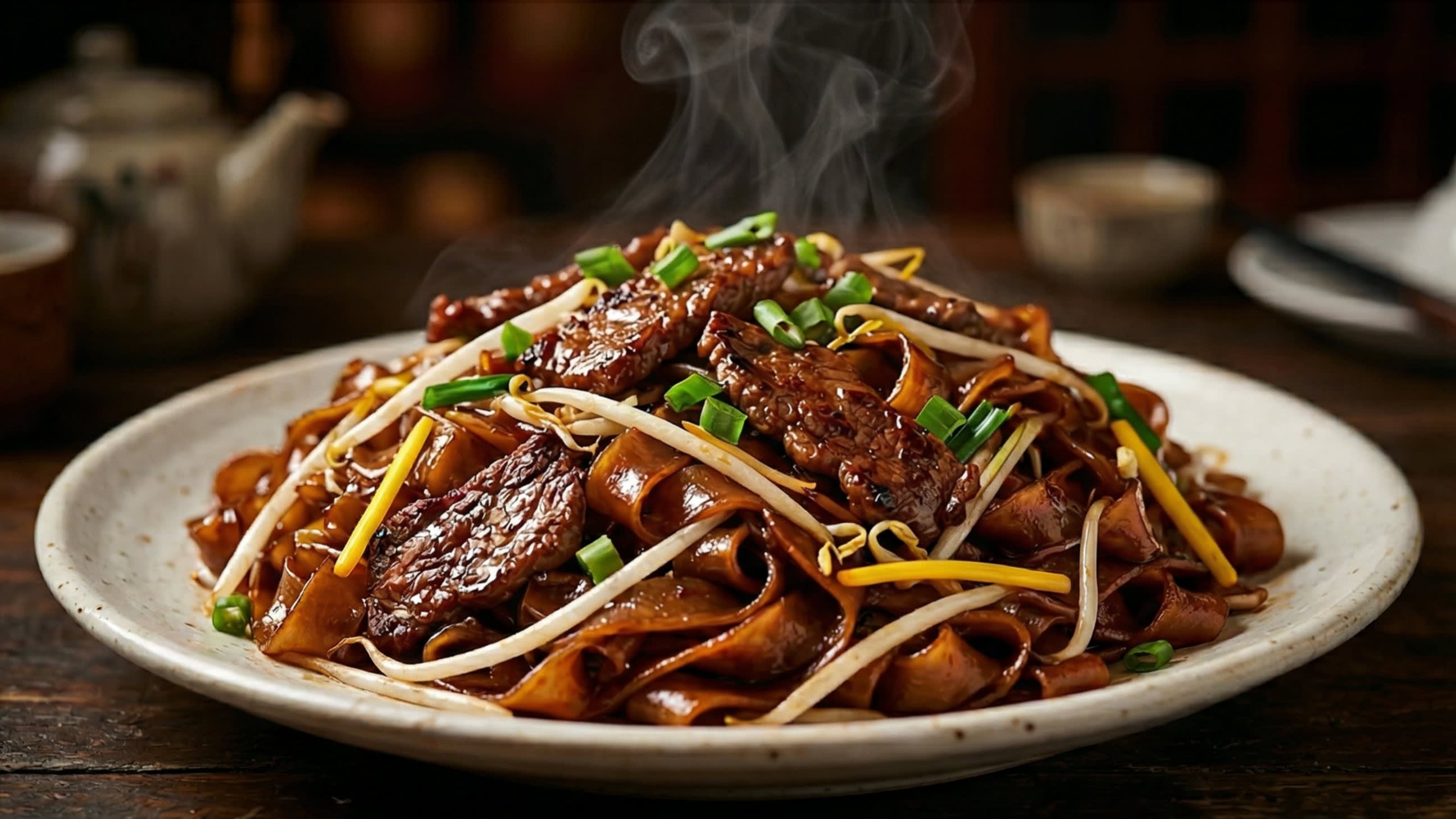 A breathtaking, high-definition close-up of a steaming plate of authentic Cantonese Beef Chow Fun. The wide, flat rice noodles are glossy, intact, and beautifully stained a deep caramelized mahogany-brown. They are intertwined with velvety strips of seared beef, crisp white mung bean sprouts, and bright yellow chives. A subtle wisp of hot, smoky steam is rising in the cinematic lighting.
