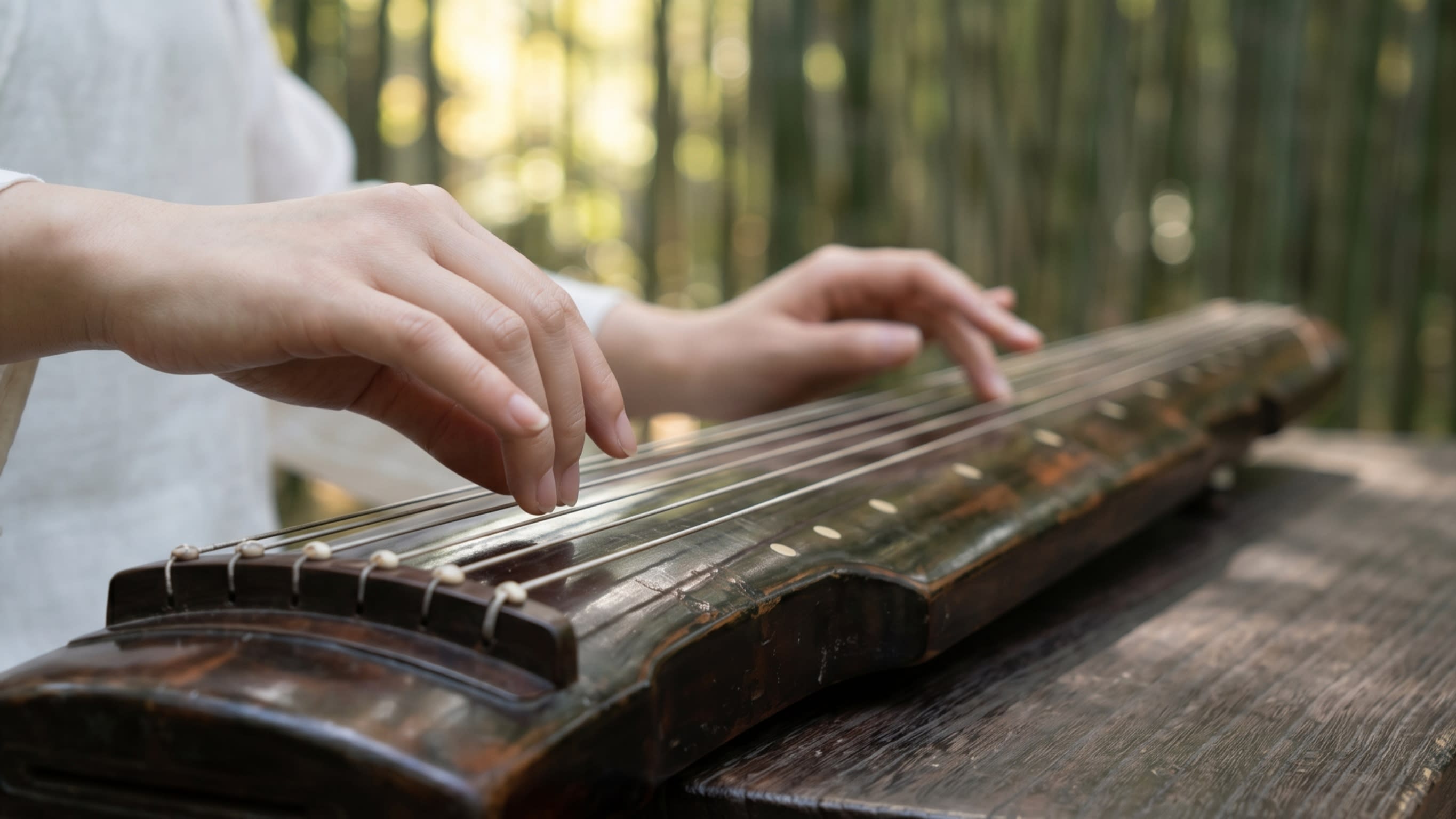 Image 2 - Ancient resonance: The delicate touch of a Guqin master in a bamboo grove
