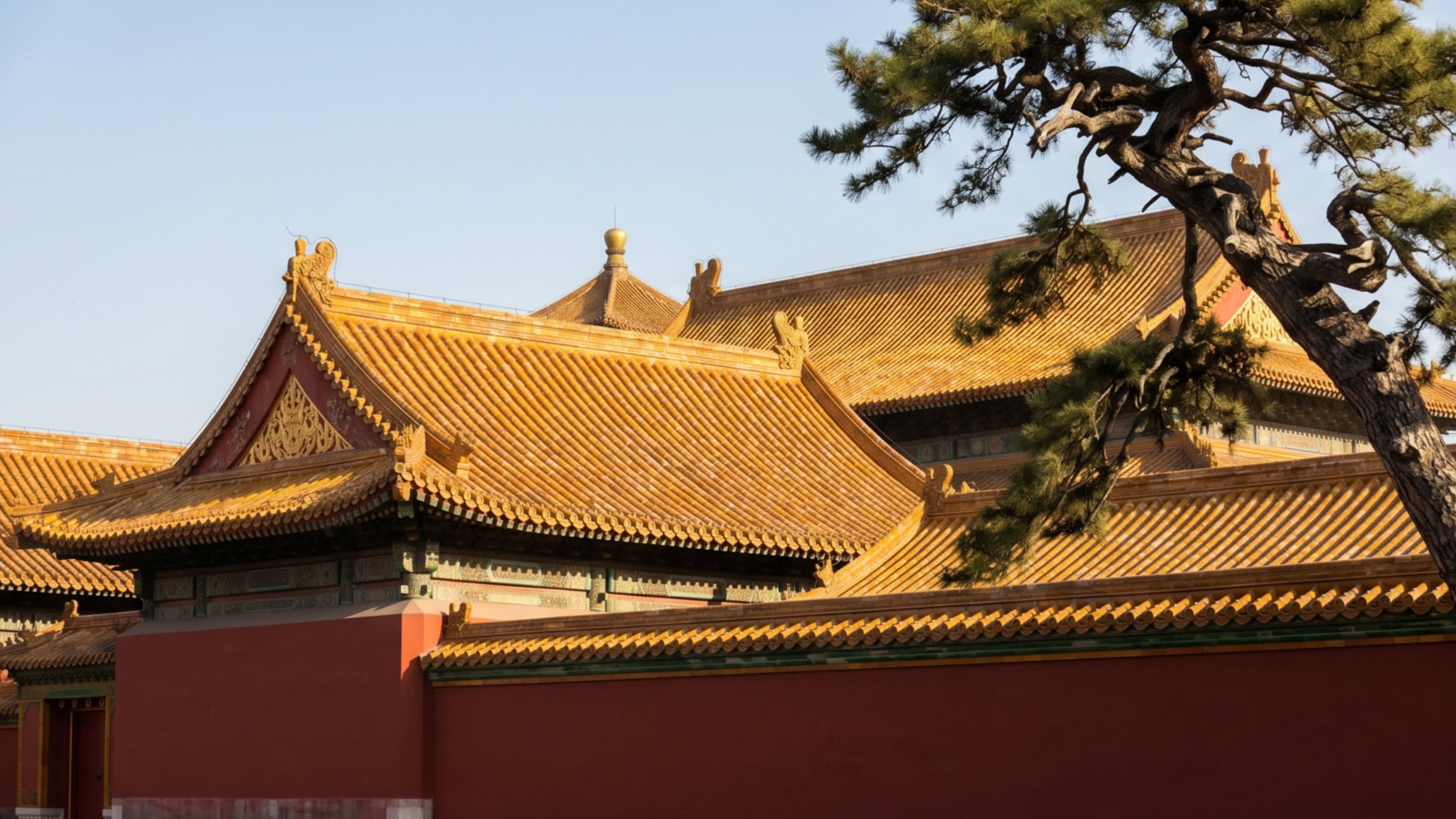 The majestic, symmetrical red walls of the Forbidden City standing against a clear sky