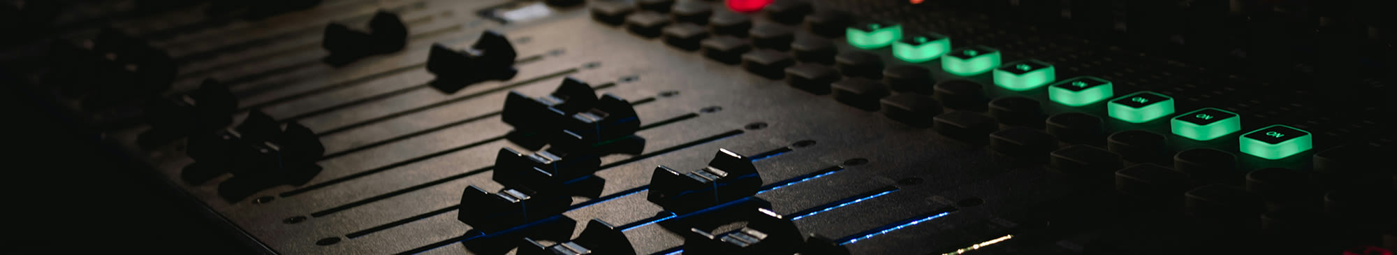 soundboard with green lit up buttons and faders