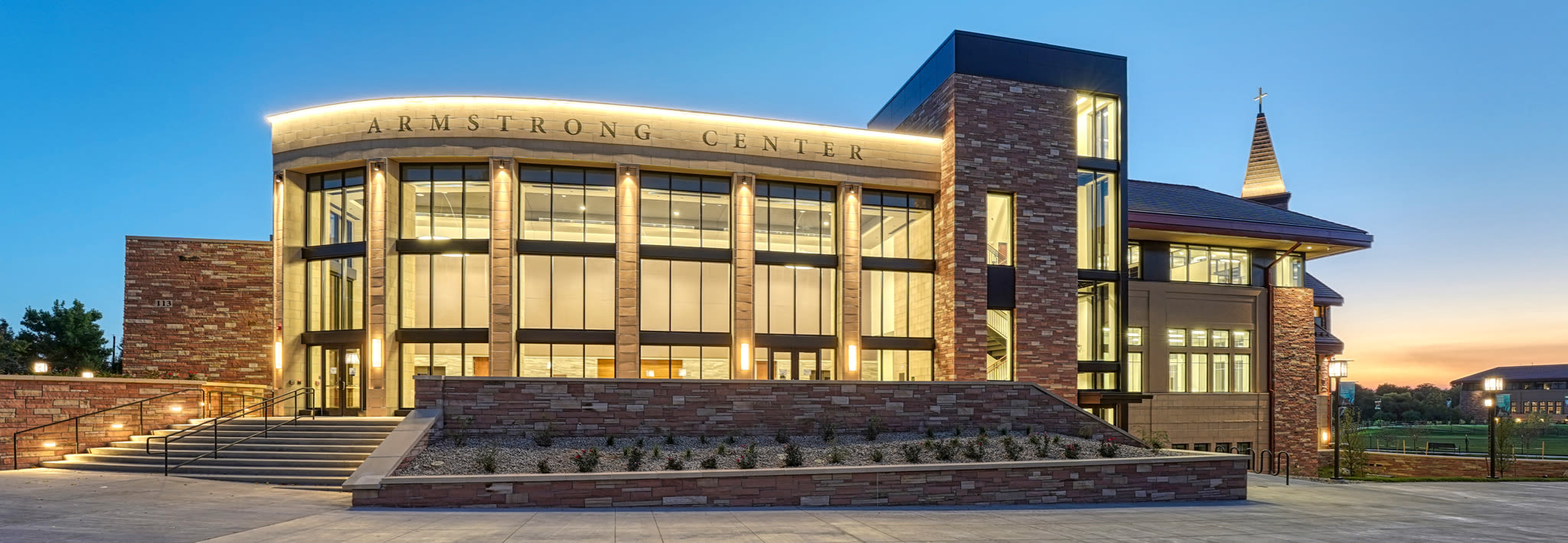 The exterior of CCU's Armstrong Center lit up at twilight.