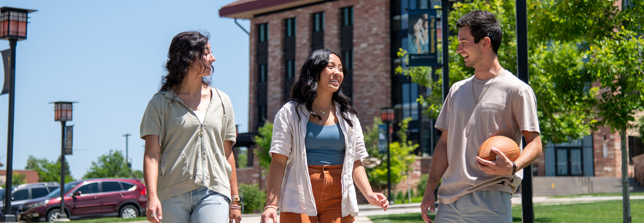 three students walking outside on campus