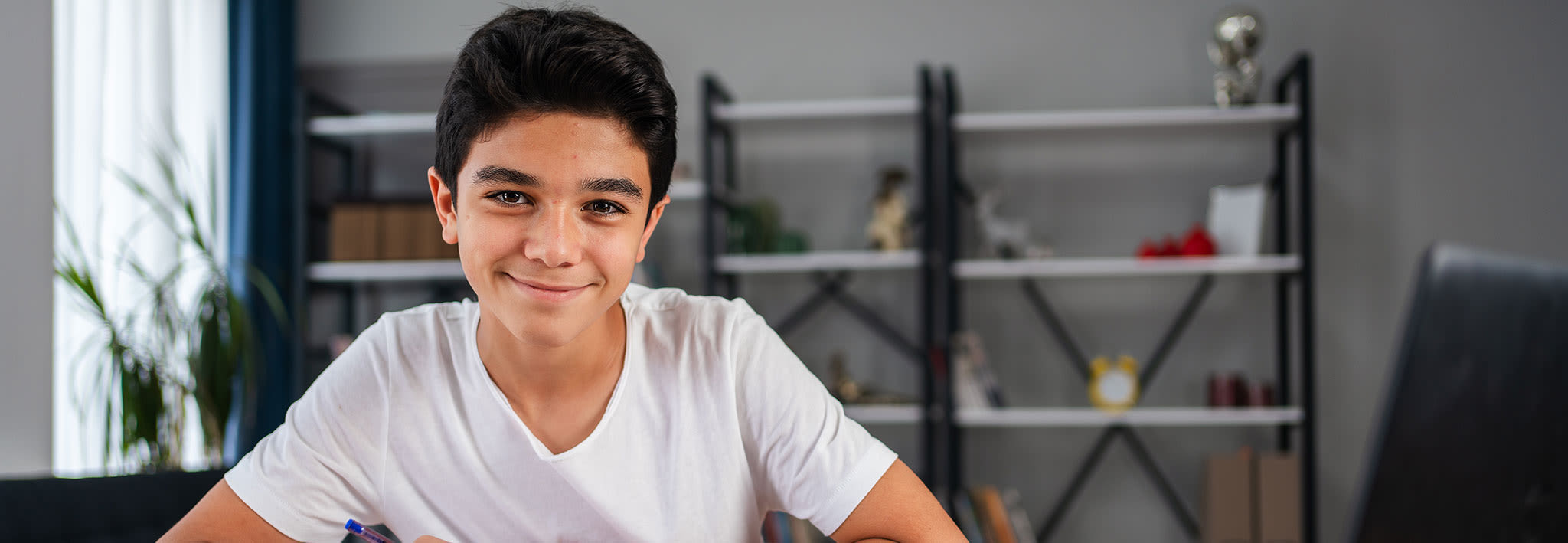 young student smiling at his desk