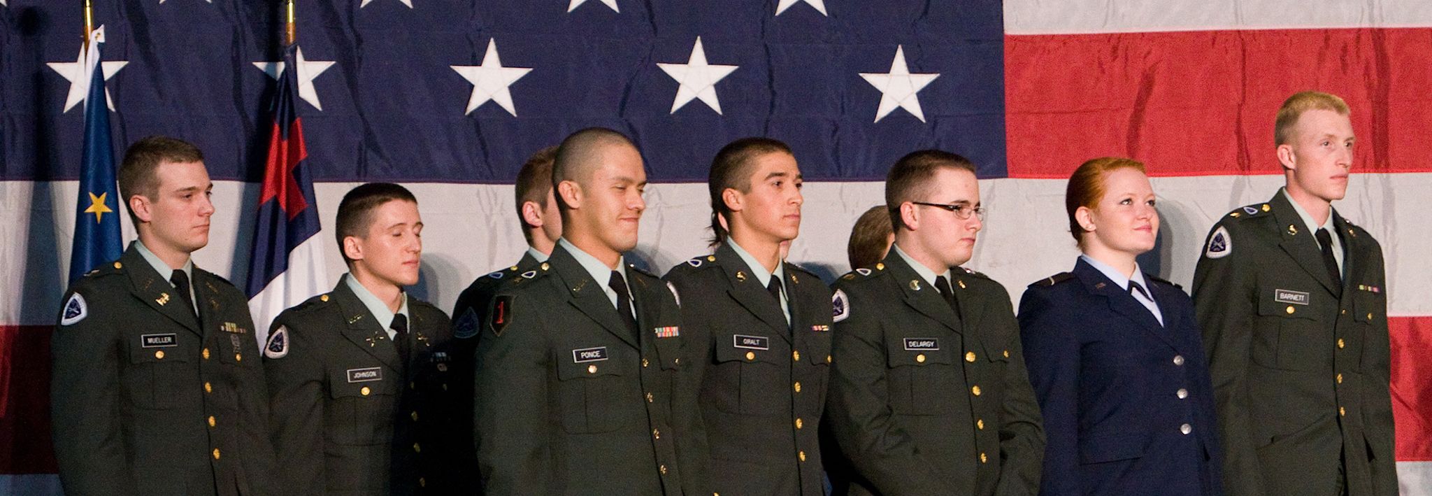 Colorado Christian University students involved in ROTC pose for a photo in front of an American flag.