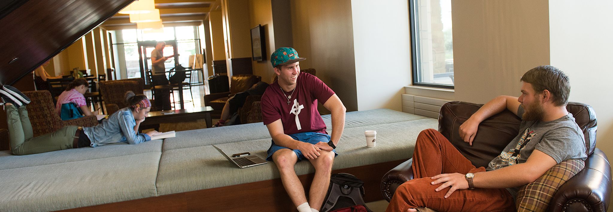 Two students are lounging in Leprino Hall at CCU.