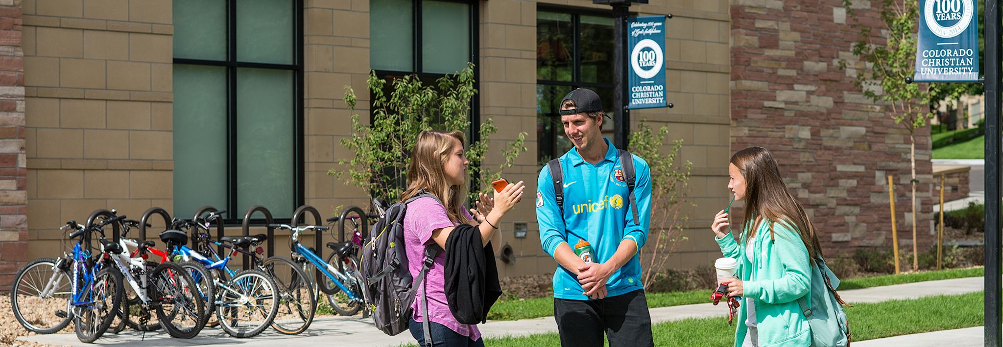 A group of students are talking outside on the CCU campus.