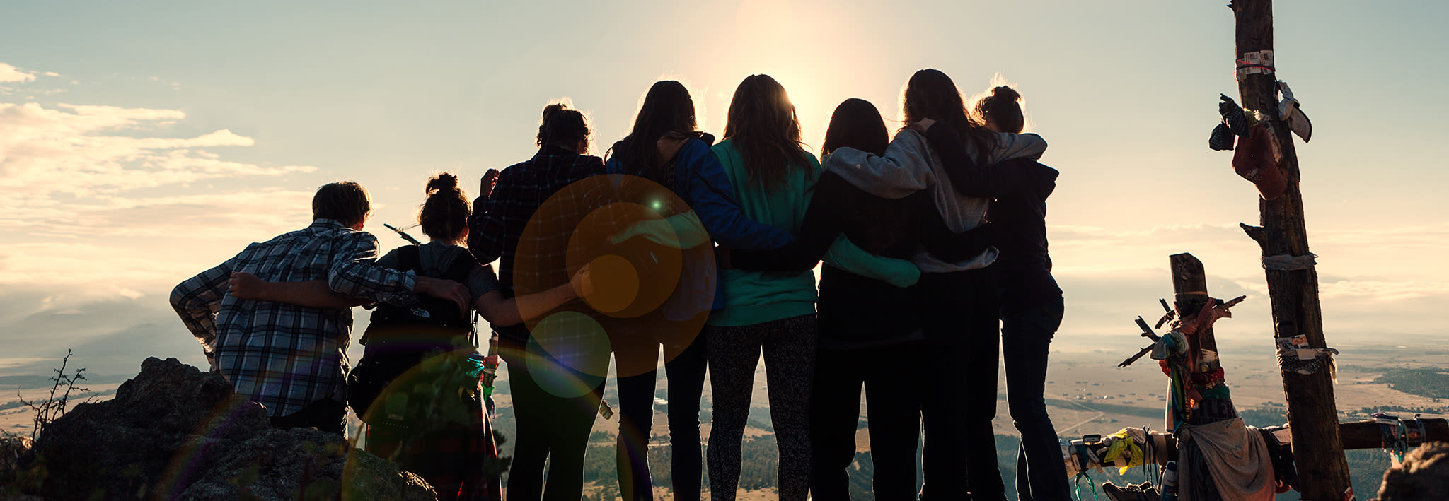 Students standing on a mountain watching sunrise