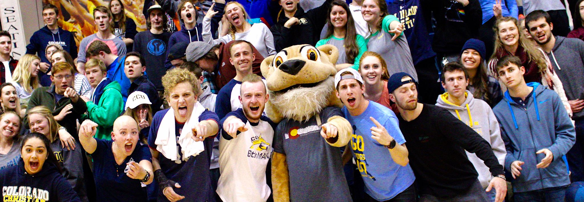 CCU students crowding around their mascot. 