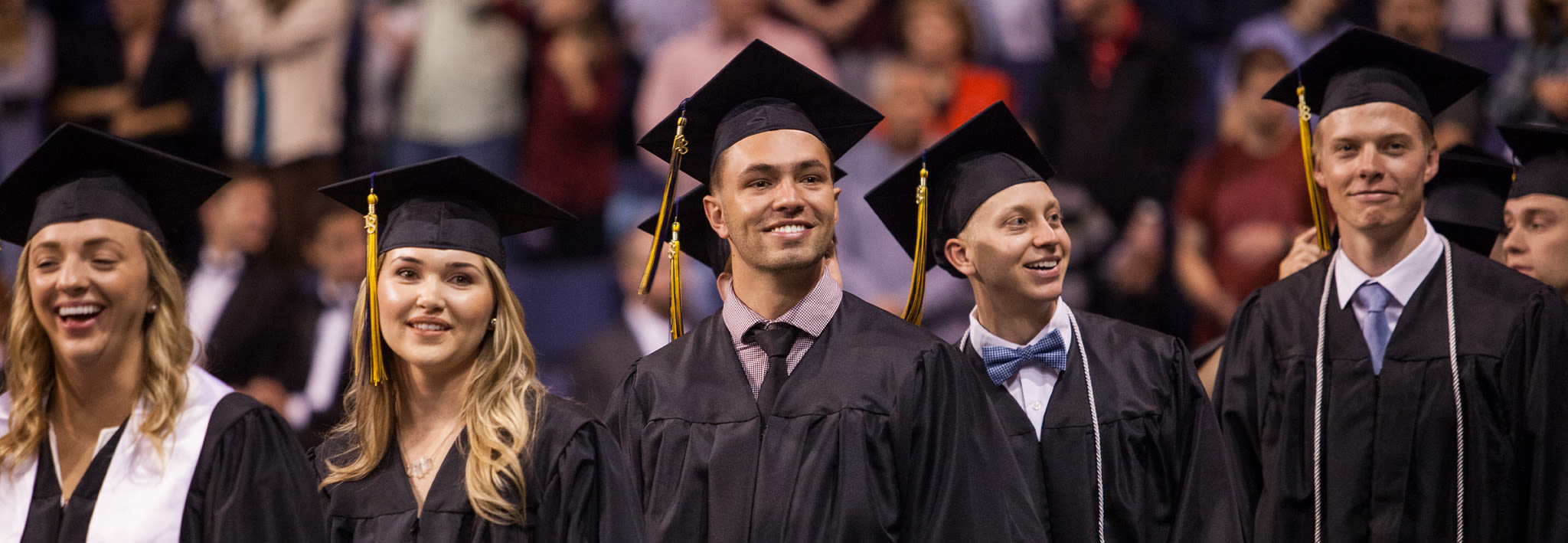 Group of adult students at CCU Commencement ceremony with smiles on their faces.