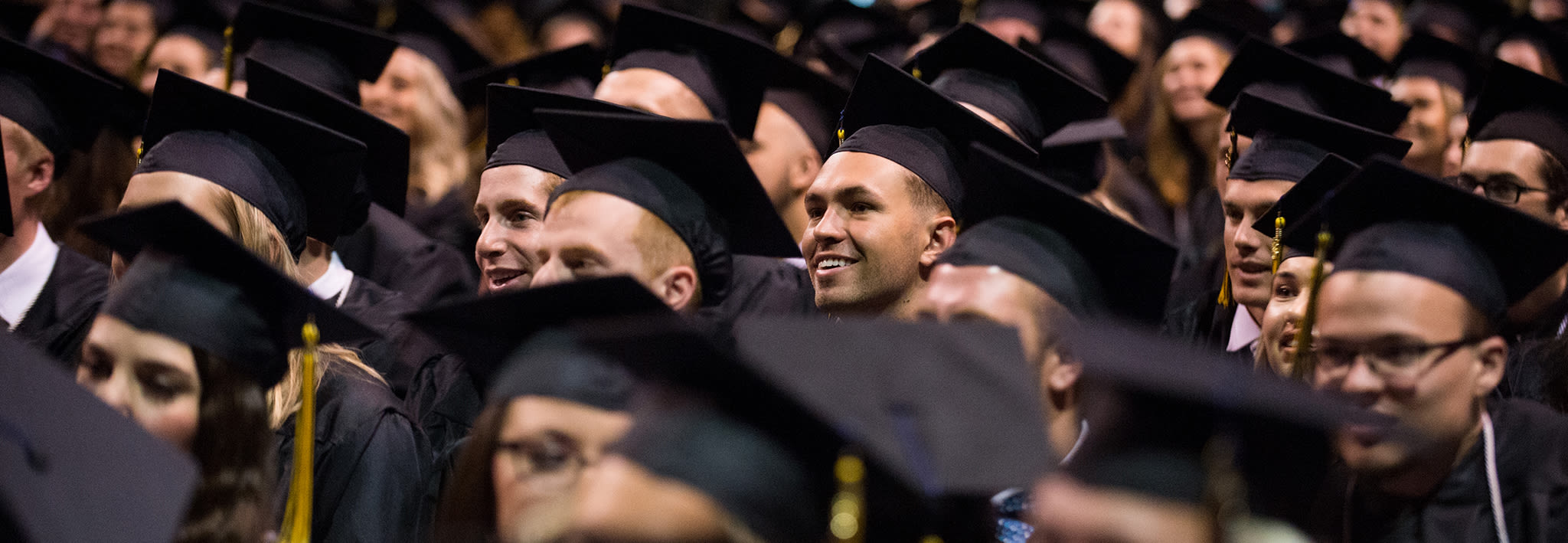 CCU graduates at Commencement ceremony all facing in the same direction.