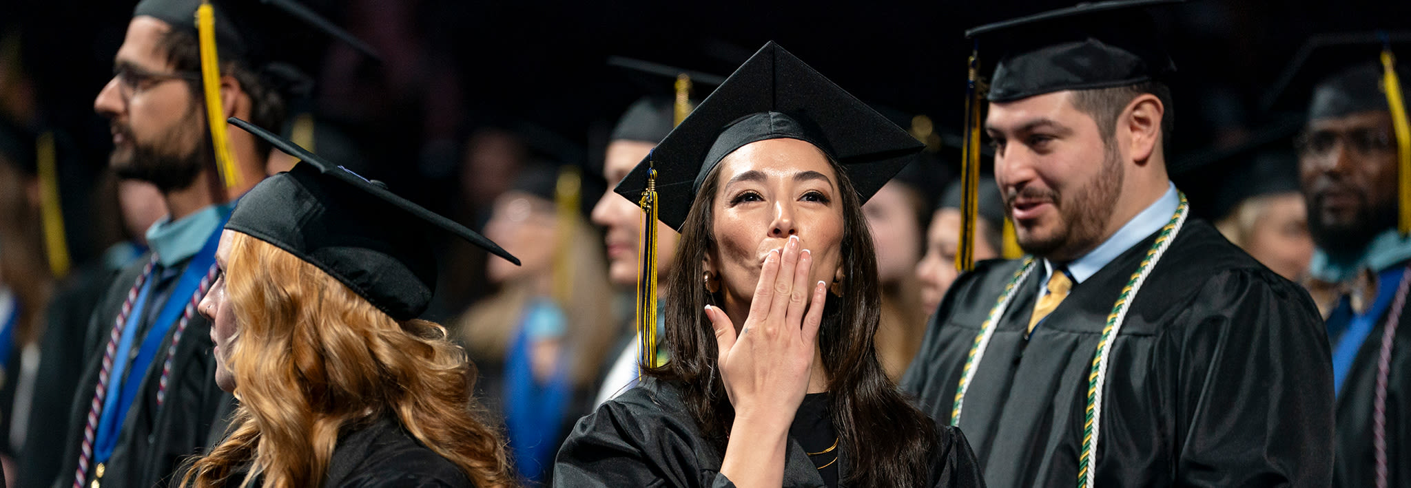 Graduate blowing a kiss at commencement 2025