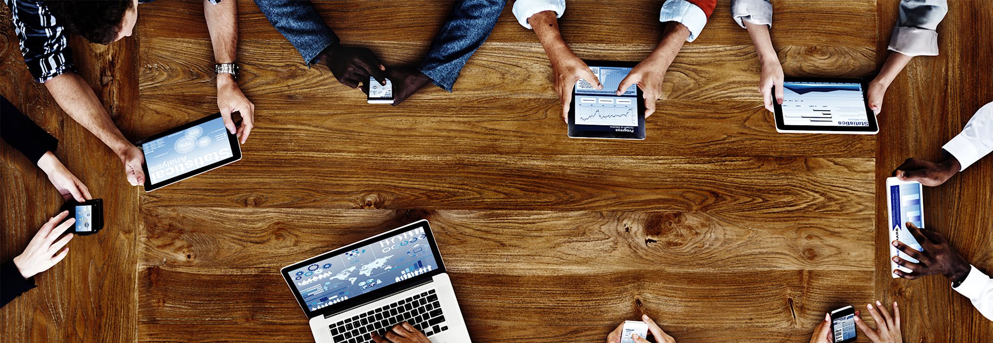 A group of marketing and sales professionals is having a meeting with their tablets and laptops.