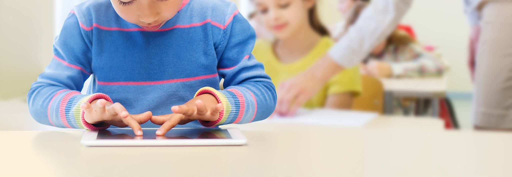 A child is using a tablet in his early childhood education class.