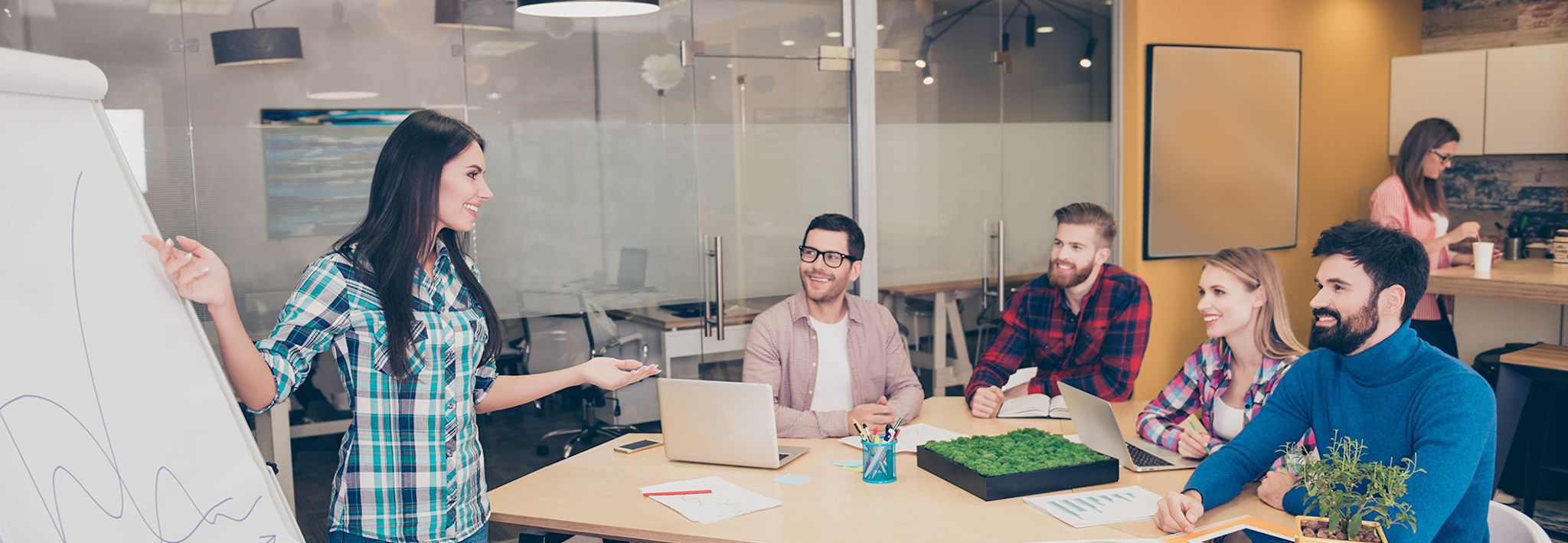 A group of creative professionals is having a team meeting in a conference room.