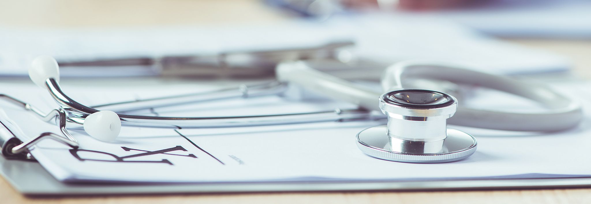 A stethoscope is laying on a doctor's notepad.