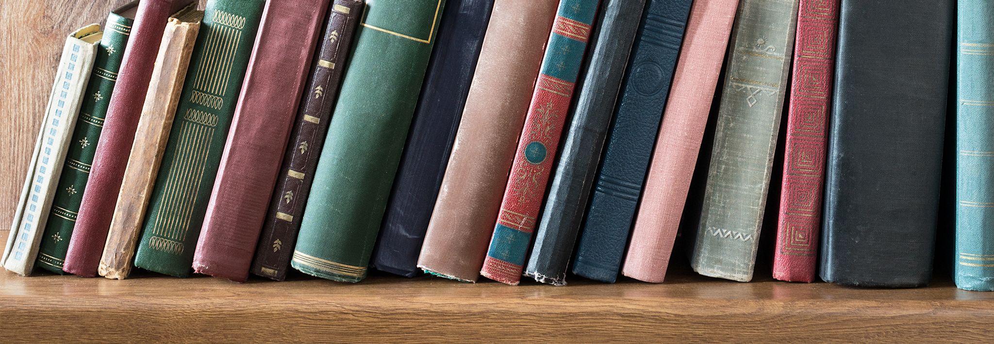 Several general studies books are leaning on a shelf.