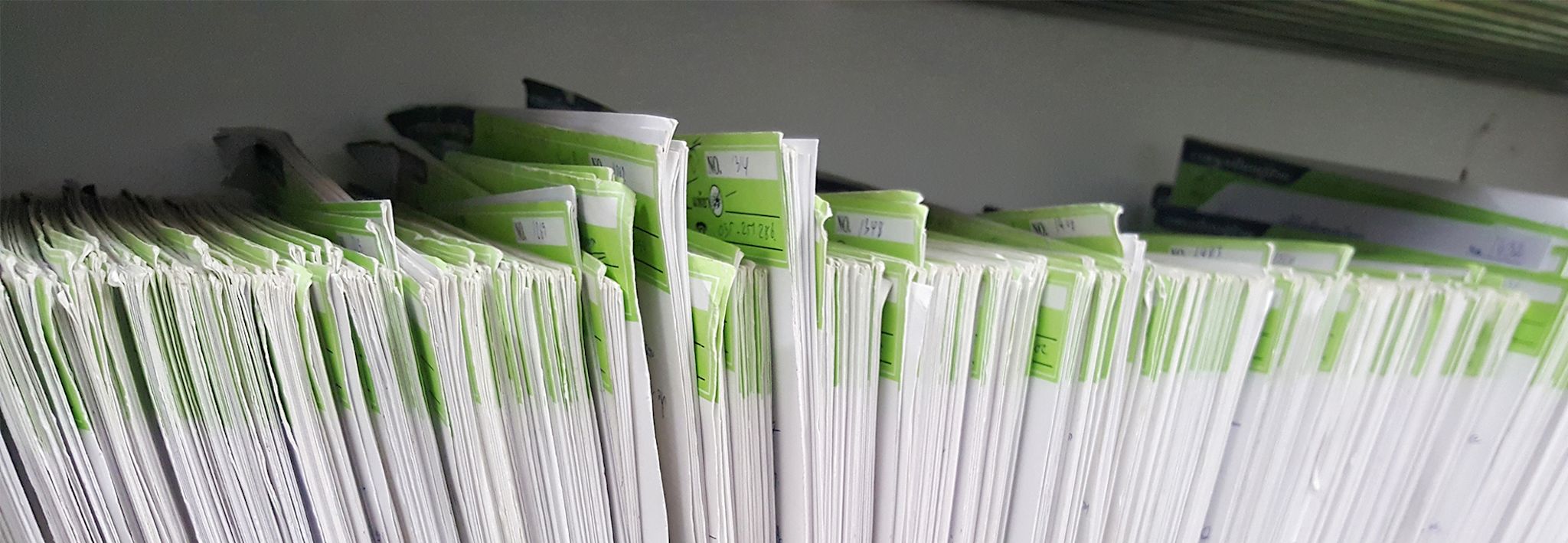 A healthcare administration office has paperwork sitting on a shelf.