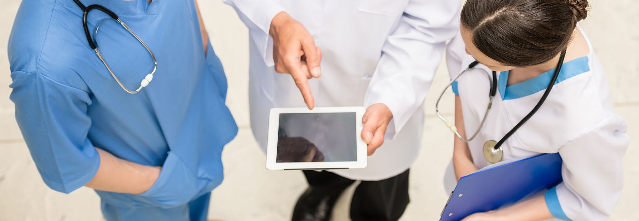 A master's in nursing student is talking with two doctors at work in a hospital.