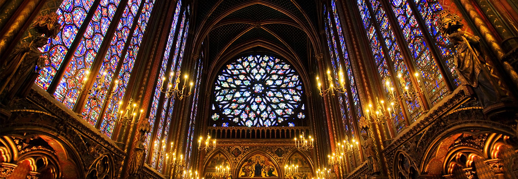 A church with stained glass A historical church has stained glass and candles throughout it.