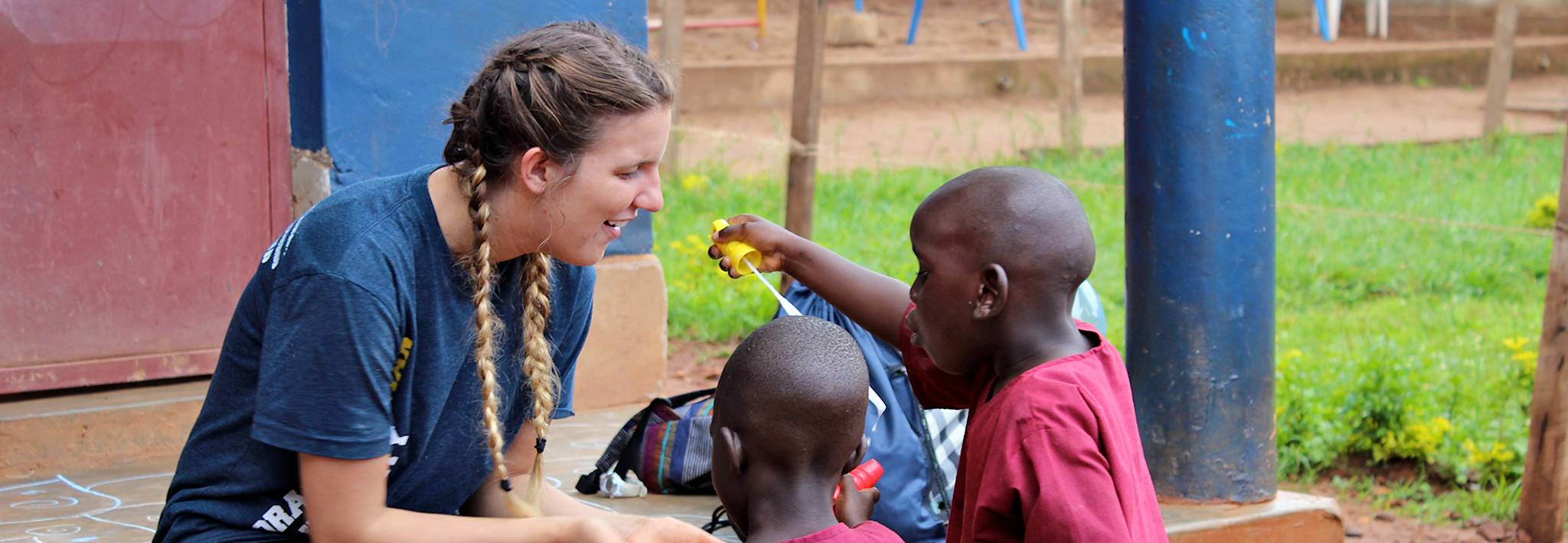 CCU student playing with kids in Uganda. 