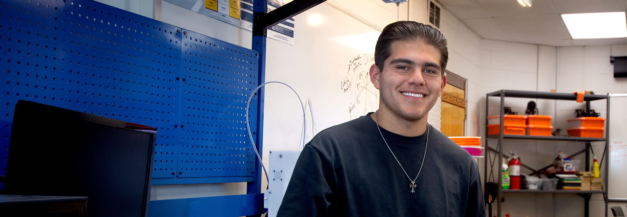 ccu engineering student smiling while standing in workshop on campus