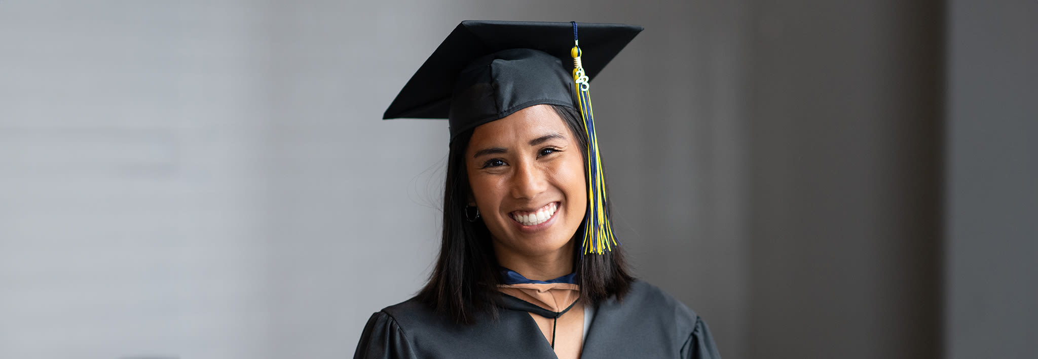 smiling ccu graduate wearing a cap and gown