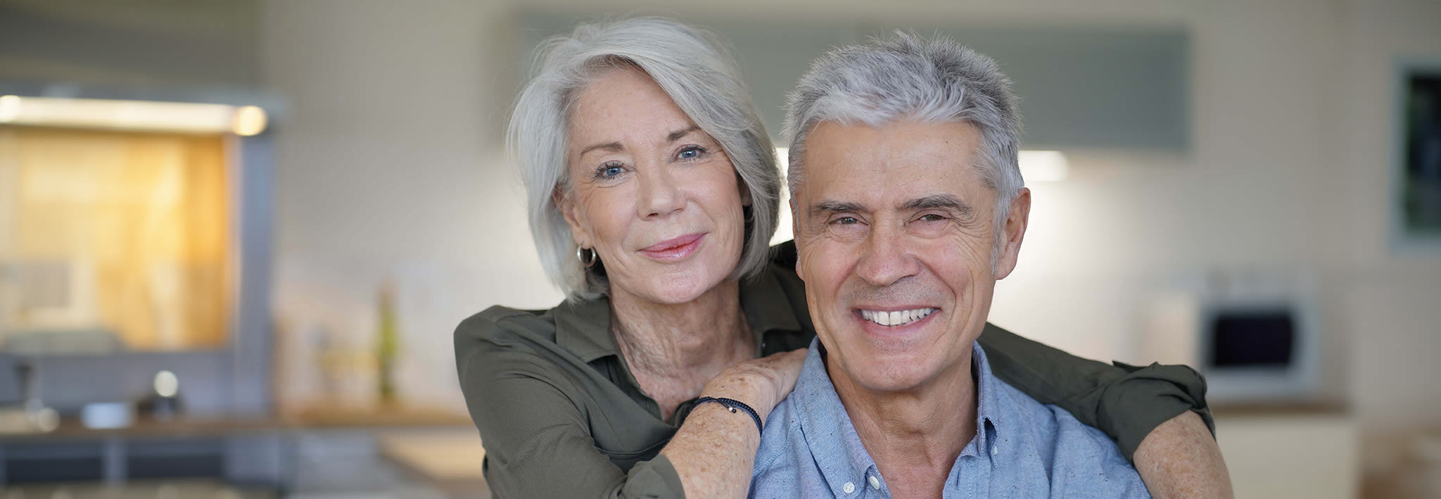 retired couple embracing and smiling