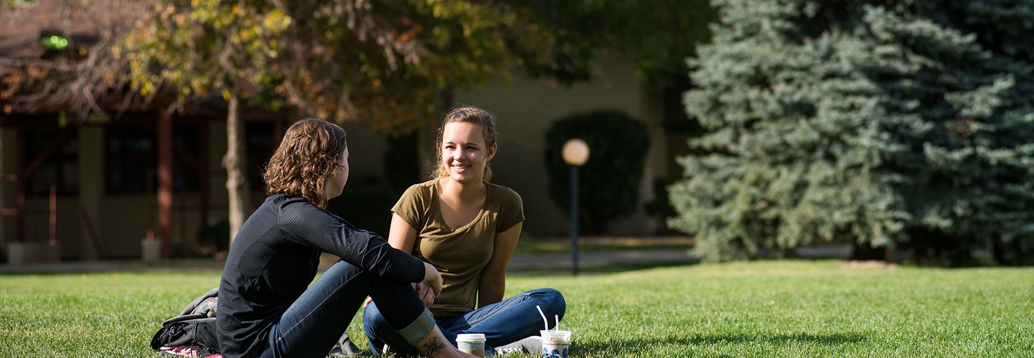 College students sitting outside on CCU's lawn. 