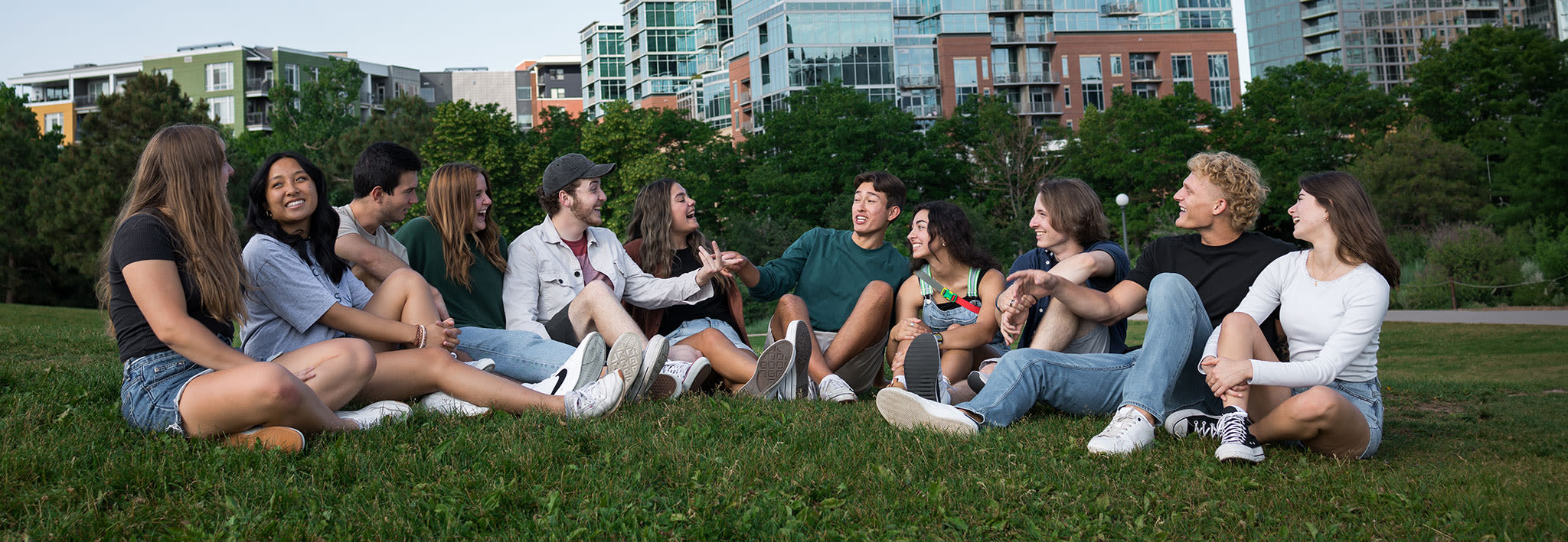 students sitting on a hill in denver talking and laughing