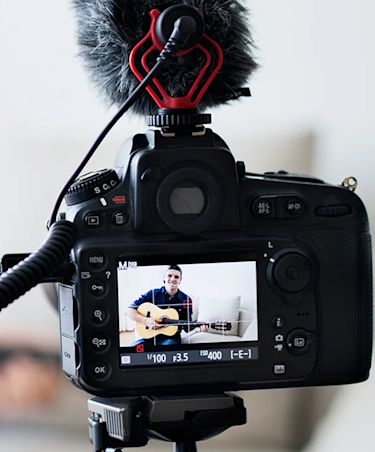 view through a camera recording a guitarist