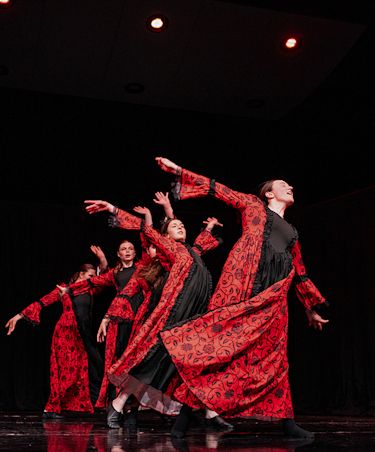 dancers performing in costumes that are red and black