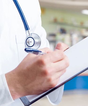 doctor in a lab coat writing on a clipboard