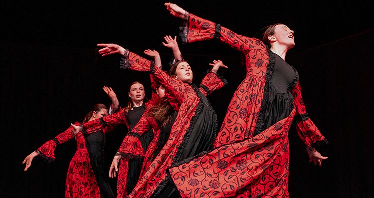 dancers performing in costumes that are red and black